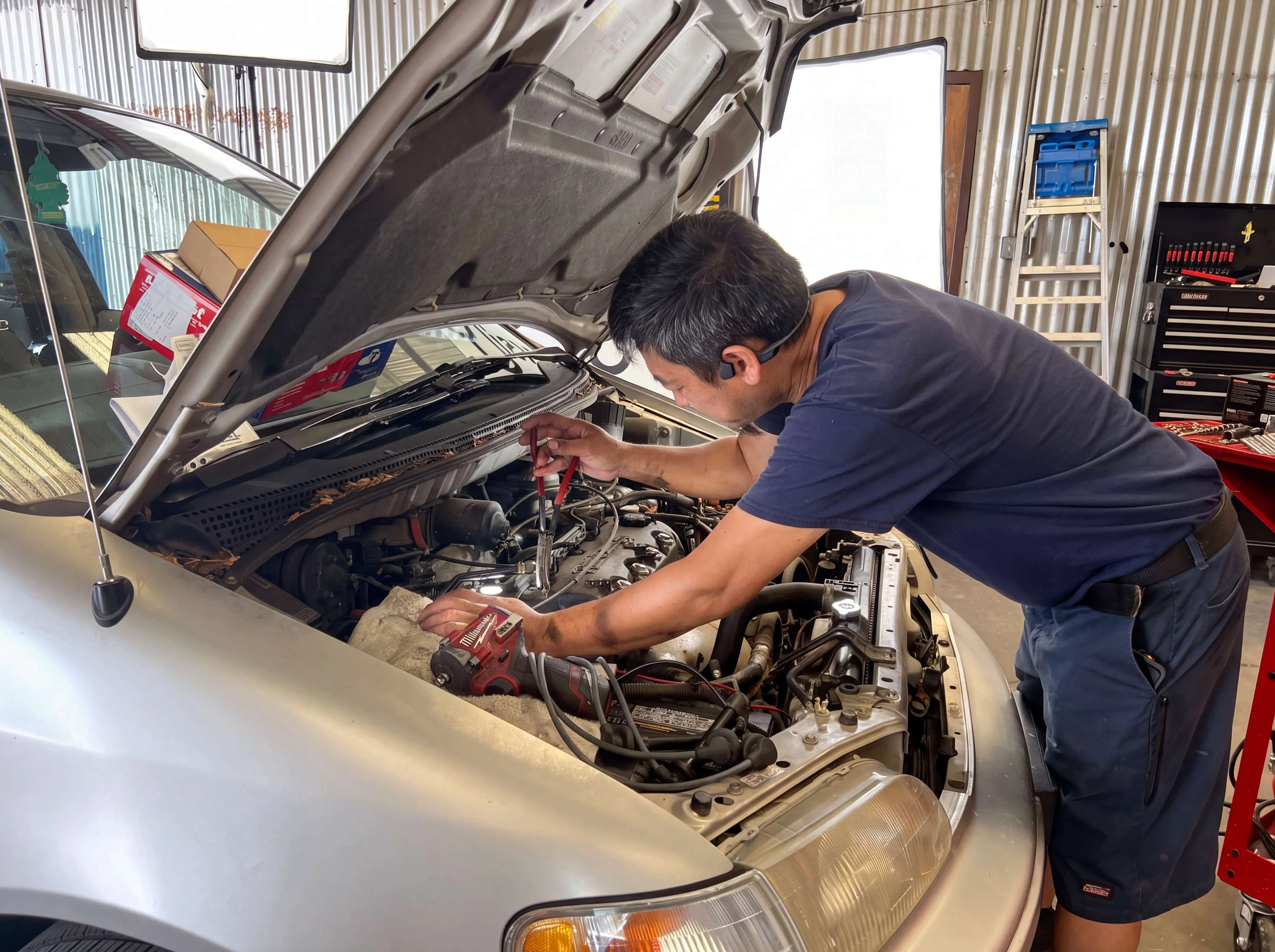 Technician working under the hood at I Care Automotive