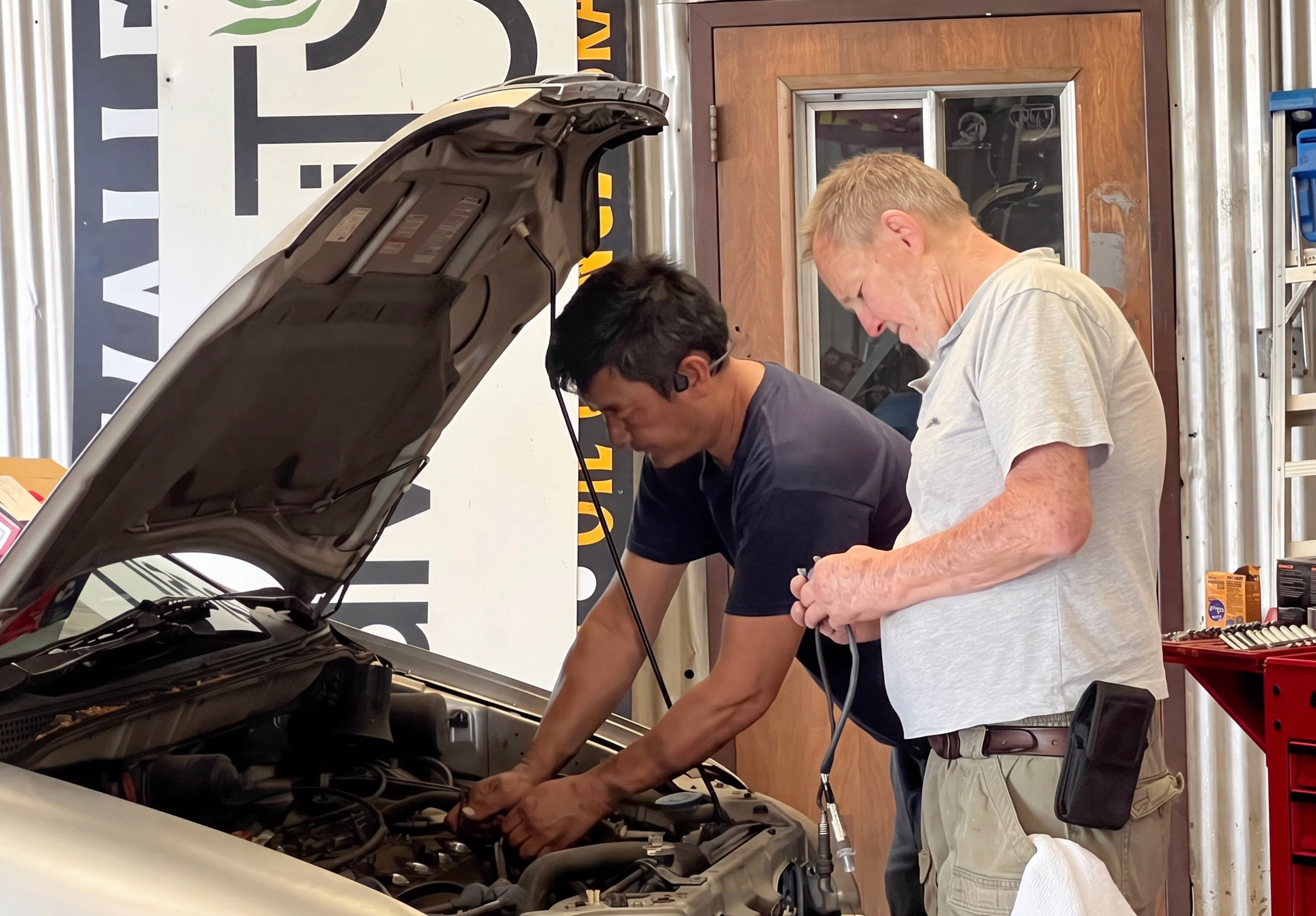 Technicians working on a vehicle at I Care Automotive